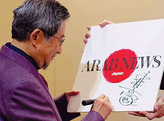 Go Nagai signing the Arab News Japan logo, which he designed, in October 2019