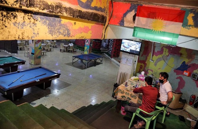 Mask-clad men sit at the entrance of a local recreational centre with pool tables and table tennis tables in the historic city of Shaqlawah, in the northern Iraqi Kurdish autonomous region on June 25, 2020. (File/AFP)