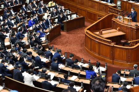 Japan's Prime Minister Yoshihide Suga (right), wearing a face mask, gives his first policy speech during an extraordinary session at the lower house of parliament in Tokyo on October 26, 2020. (AFP)