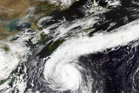 A satellite image released by NASA Worldview, Earth Observing System Data and Information System (EOSDIS) shows Typhoon Chan-hom advancing northward on Wednesday over waters south of Japan. (NASA via AP)