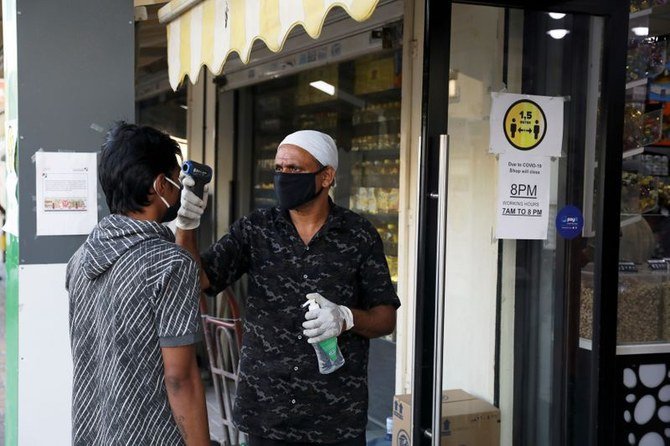 A man wearing a protective face mask has his temperature taken outside a corner store, following the outbreak of the coronavirus disease (COVID-19), in the Al-Quoz industrial district of Dubai, UAE. (File/Reuters)