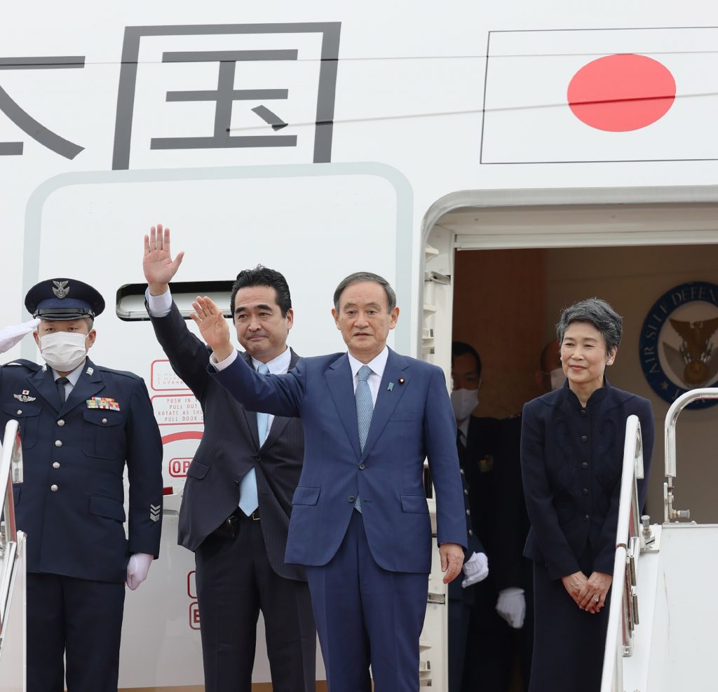 Japanese Prime Minister Yoshihide Suga (C), accompanied by his wife Mariko Suga (R), waves to well-wishers upon his departure at Tokyo's Haneda airport on October 18, 2020 for a four-day visit to Vietnam and Indonesia (AFP)