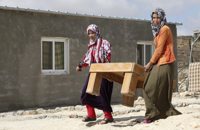 Palestinians remove belongings before Israeli forces demolish their makeshift homes in the village of Al-Tweineh, in the southern West Bank. (File/AFP)