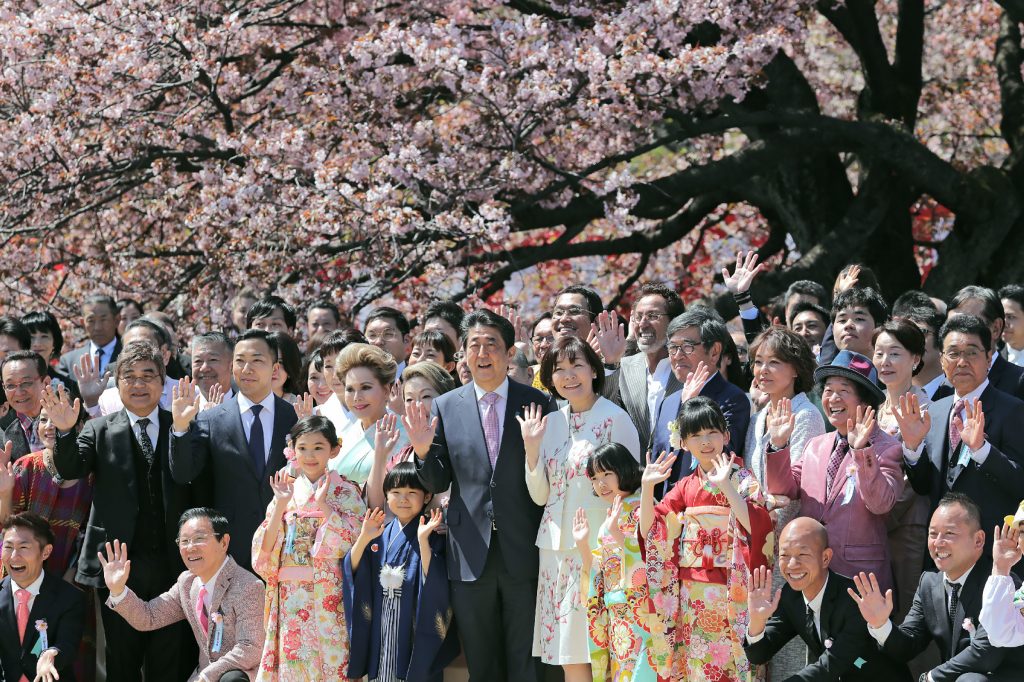 Japanese Prime Minister Shinzo Abe (centre L) and his wife Akie (center R) pose for pictures with their guests during his cherry blossom viewing party at a park in Tokyo on April 13, 2019. (AFP)