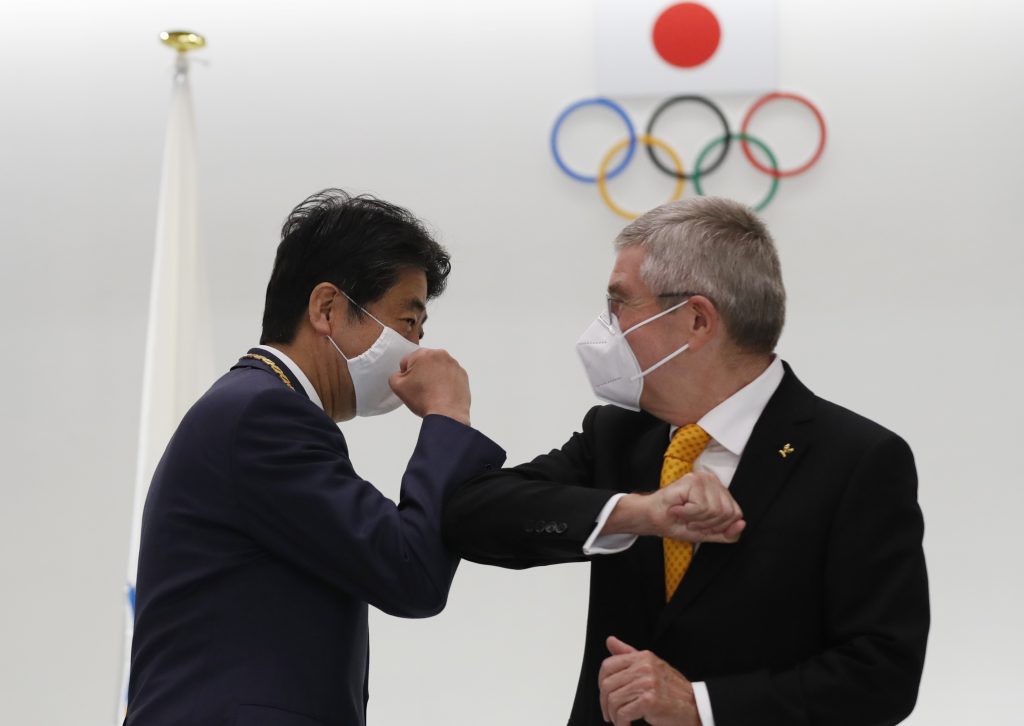 Japan's former prime minister Shinzo Abe talks with International Olympic Committee (IOC) president Thomas Bach after a ceremony awarding the Olympic Order to Abe by the IOC, at the Japan Olympic Museum in Tokyo on November 16, 2020. (AFP)