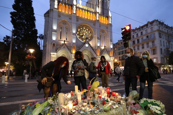 People gather outside Notre-Dame de l'Assomption Basilica in Nice on October 31, 2020, to pay tribute to the victims two days after a knife attacker killed three people. (AFP)