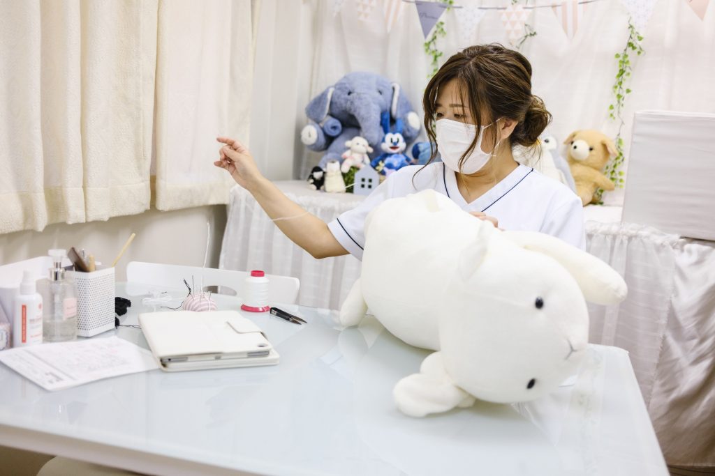 Founder Natsumi Hakozaki working on client Yui Kato's stuffed toy sheep Yuki-chan at Natsumi Clinic in Toyko. The clinic specialises in restoring much-loved teddies and other cuddly toys to their original glory, delighting deeply attached owners like Yui Kato, who brought in the sheep. (File photo/AFP)