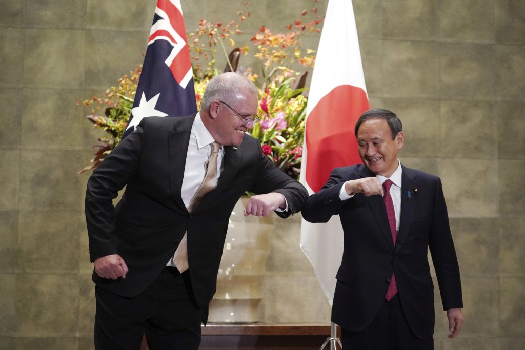 Australian Prime Minister Scott Morrison, left, and Japanese Prime Minister Yoshihide Suga bump elbows to greet prior to the official welcome ceremony at Suga's official residence in Tokyo Tuesday, Nov. 17, 2020. Morrison is in Japan to hold talks with Suga to bolster defense ties between the two US allies to counter China's growing assertiveness in the Asia-Pacific region. (AP Photo/Eugene Hoshiko)