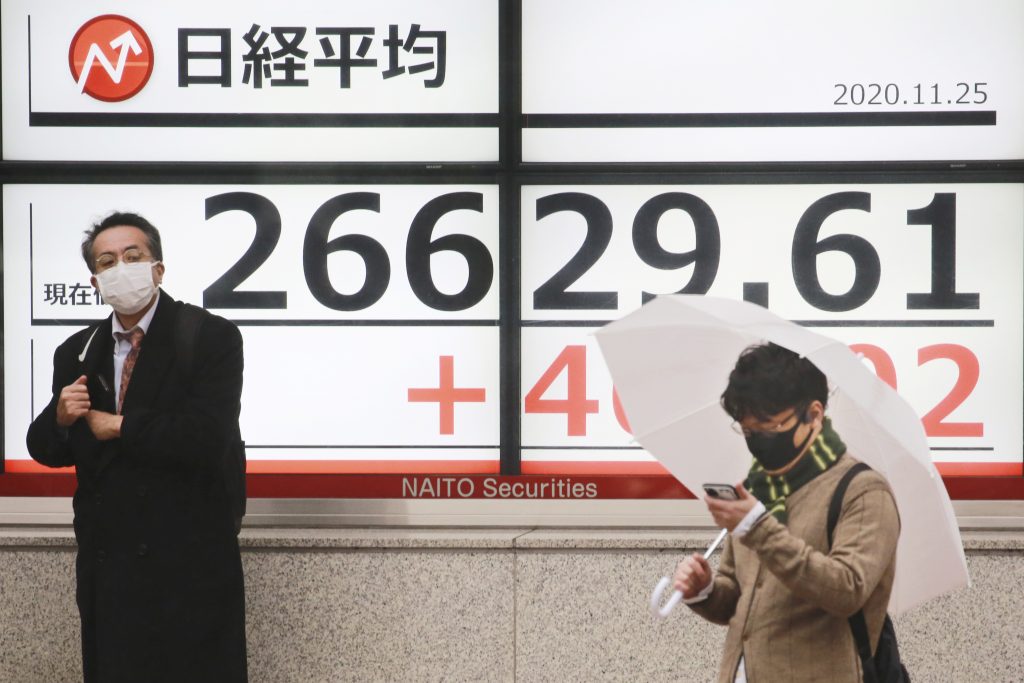 People stand by an electronic stock board of a securities firm showing Japan's Nikkei 225 index in Tokyo, Wednesday, Nov. 25, 2020. (File photo/AP)