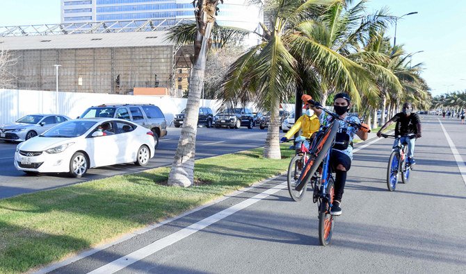 Saudi youths ride bicycles at the seafront promenade in the Saudi seaport of jeddah, on June 21, 2020, as the country re-opens following the lifting of a lockdown due to the COVID-19 pandemic. (AFP)