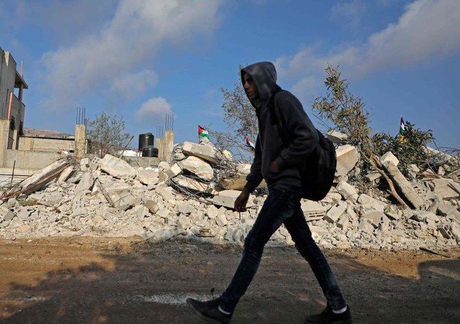 A Palestinian man walks past the remains of the home of Khalil Dweikat, a man accused of an attack that killed an Israeli rabbi earlier this year, in the West Bank village of Rujeib on Nov. 2, 2020, after it was demolished by Israeli soldiers. (AFP)