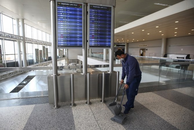 A worker wearing a face mask sweeps an empty hall of Beirut International Airport amid restrictions to combat the coronavirus across Lebanon, on March 19, 2020. (File/AFP)