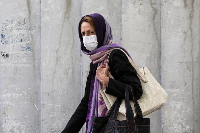 A woman, mask-clad due to the COVID-19 coronavirus pandemic, walks along a street in Iran's capital Tehran on November 8, 2020. (AFP)