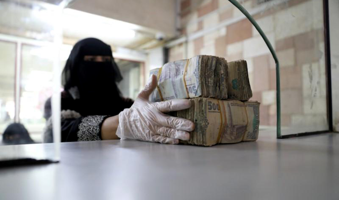 An employee takes bundles of Yemeni Riyal at the Central Bank of Yemen in Sanaa. (Reuters/File)