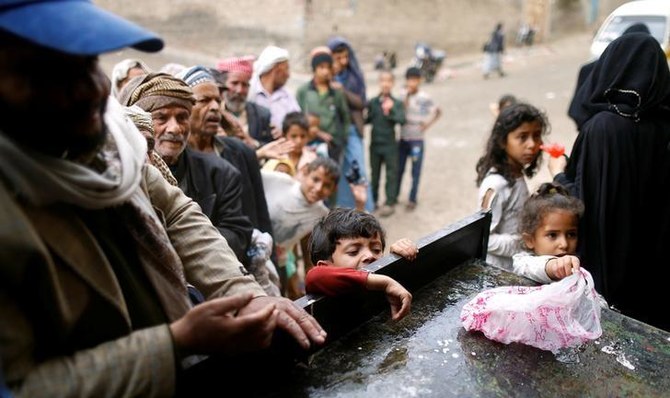 People queue to collect food rations at a food distribution center in Sanaa, Yemen. (File/Reuters)