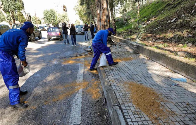 Workers clean up at the site of a car crash where prisoners who had fled a detention centre in a vehicle had died following their escape earlier, in Baabda, east of Lebanon's capital Beirut, on November 21, 2020. (AFP)