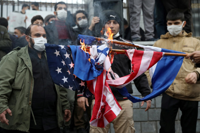 Protesters burn the flags of Israel and the US during a demonstration in Tehran on November 28, 2020, against the the killing of Mohsen Fakhrizadeh, Iran's top nuclear scientist. (Majid Asgaripour/West Asia News Agency via REUTERS)