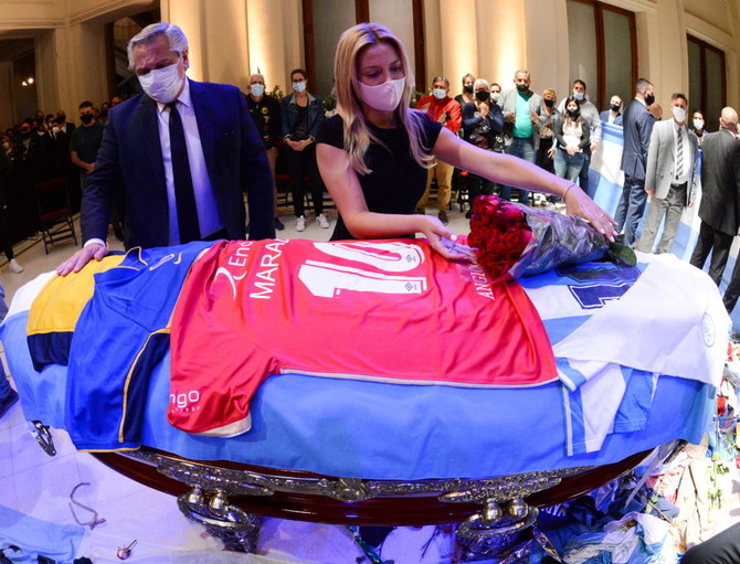 Argentina's first lady Fabiola Yanez places flowers on the casket of soccer legend Diego Maradona as Argentina's President Alberto Fernandez looks on, at the presidential palace Casa Rosada, in Buenos Aires, Argentina November 26, 2020. (Reuters)