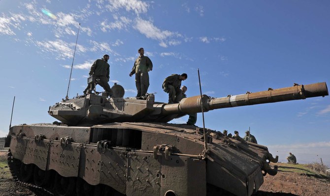 A picture taken on November 25, 2020 shows Israeli soldiers and a tank near the Israel-Syria border, in the Israeli-annexed Golan Heights. (AFP)