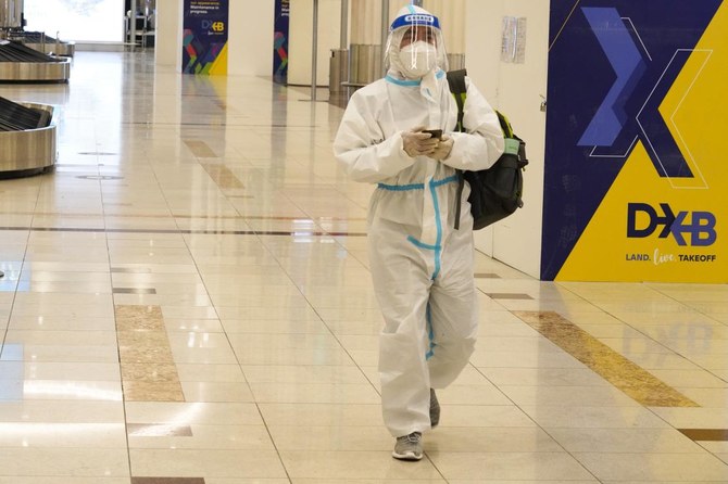 A passenger in a full, disposable hazmat suit arrives at the baggage claim area of Dubai International Airport's Terminal 3 in Dubai, United Arab Emirates, Thursday, Nov. 26, 2020. (AP)