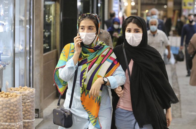 Mask-clad Iranians shop at the Tajrish Bazaar market in the capital Tehran, on Sunday. (AFP)