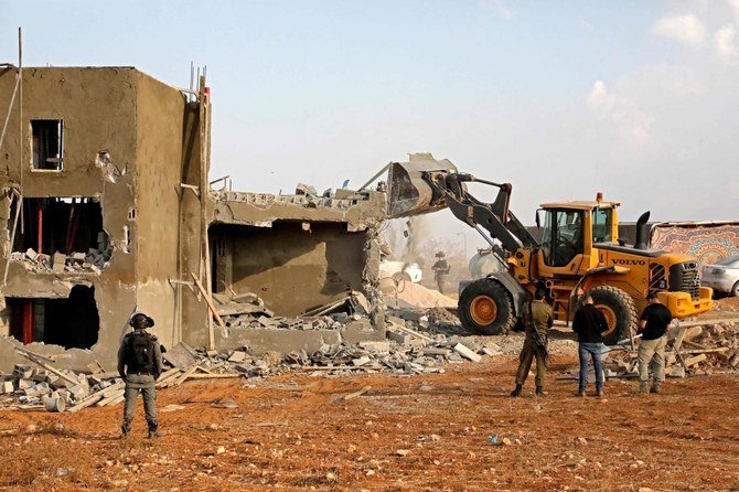 Israeli machinery demolish a Palestinian house located within the area C (where Israel retains control, including over planning and construction) in a village south of Yatta in the southern area of the West Bank town of Hebron, on November 2, 2020. (AFP)