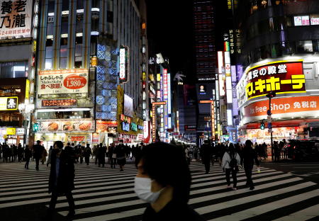 Pedestrians wearing protective masks, following the coronavirus disease (COVID-19) outbreak, make their way on a crosswalk at a nightlife district in Tokyo, Japan, November 26, 2020. (Reuters)