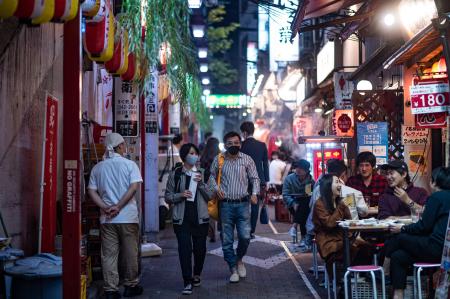 People wearing face masks as a preventive measure against the Covid-19 coronavirus, visit the restaurant area of Omoide Yokocho alleyway in Shinjuku district of Tokyo on November 19, 2020. (AFP)