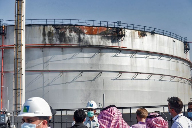 Journalists look at a damaged silo a day after an attack at the Saudi Aramco oil facility in Saudi Arabia's Red Sea city of Jeddah, on November 24, 2020. (AFP)