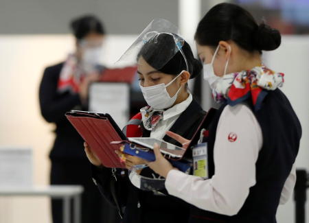 Employees of Japan Airlines (JAL) wearing protective face masks are seen at the departure zone of Narita international airport, where there are fewer passengers than usual, amid the coronavirus disease (COVID-19) outbreak, in Narita, east of Tokyo, Japan November 2, 2020. (Reuters)