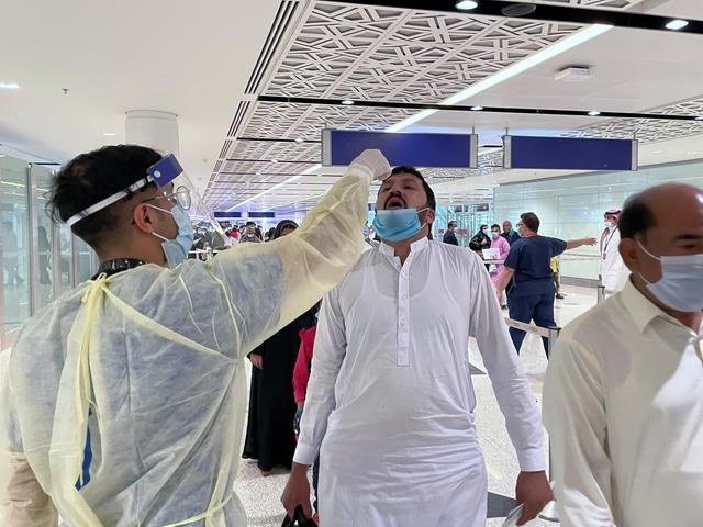 Saudi medical staff give oral medication to the first batch of Muslims arriving from international flights to perform Umrah. (File/Reuters)