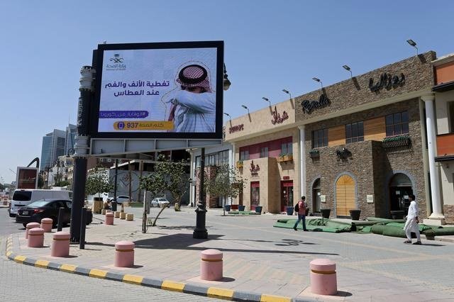 People walk near a banner with an instruction on personnel hygiene, following the outbreak of coronavirus, at a street in Riyadh, Saudi Arabia, March 16, 2020. (Reuters)