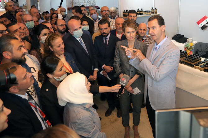 Syrian President Bashar Assad and first lady Asma Assad speak during his visit to the ‘Producers 2020’ exhibition, in Damascus, Syria, Wednesday, Nov. 4, 2020. (AP Photo)