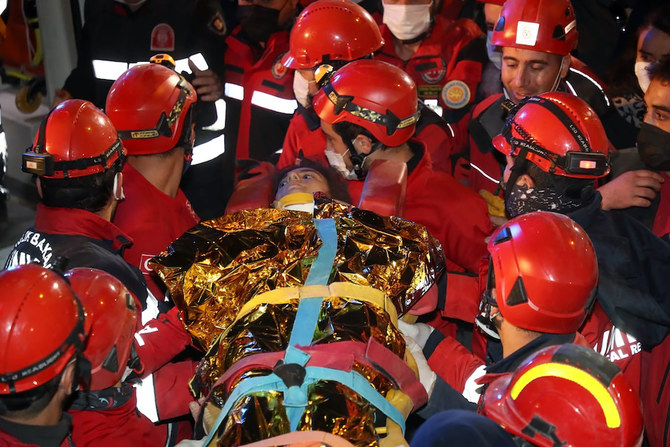 Rescue workers, who were trying to reach survivors in the rubble of a collapsed building, carry 14-year-old Idil Sirin who have been extricated from a collapsed building early Monday, Nov. 2, 2020, 58 hours after a strong earthquake in Izmir, Turkey. (IHA via AP)