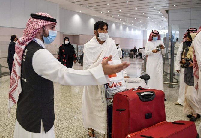 A Pakistani traveller arrives in Saudi Arabia to perform the Umrah pilgrimage and is welcomed at King Abdulaziz International Airport in Jeddah on November 1, 2020. (AFP)