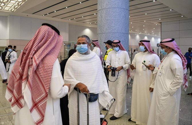A mask-clad Pakistani traveller arriving in Saudi Arabia to perform the Umrah pilgrimage, is welcomed at King Abdulaziz International Airport in the city of Jeddah on November 1, 2020. (AFP)