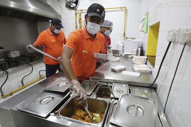 Cooks prepare free food for needy people at a restaurant in Sharjah, United Arab Emirates, Wednesday, Nov. 4, 2020. (AP)