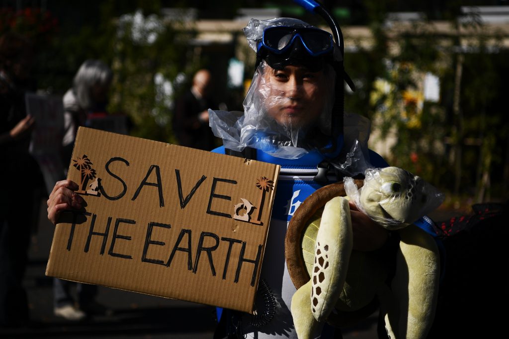 A participants holds up a placard to call for action on climate change during a march in Tokyo on Nov. 29, 2019.(AFP)