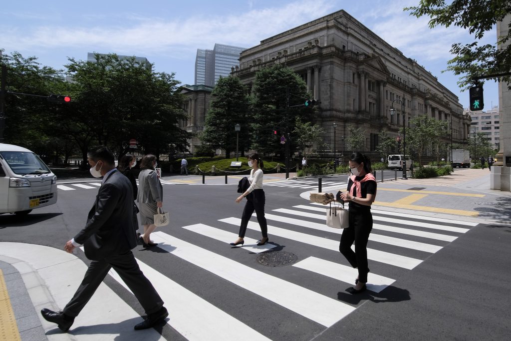 Pedestrians cross the street in front of the Bank of Japan headquarters (behind) in Tokyo. (AFP)