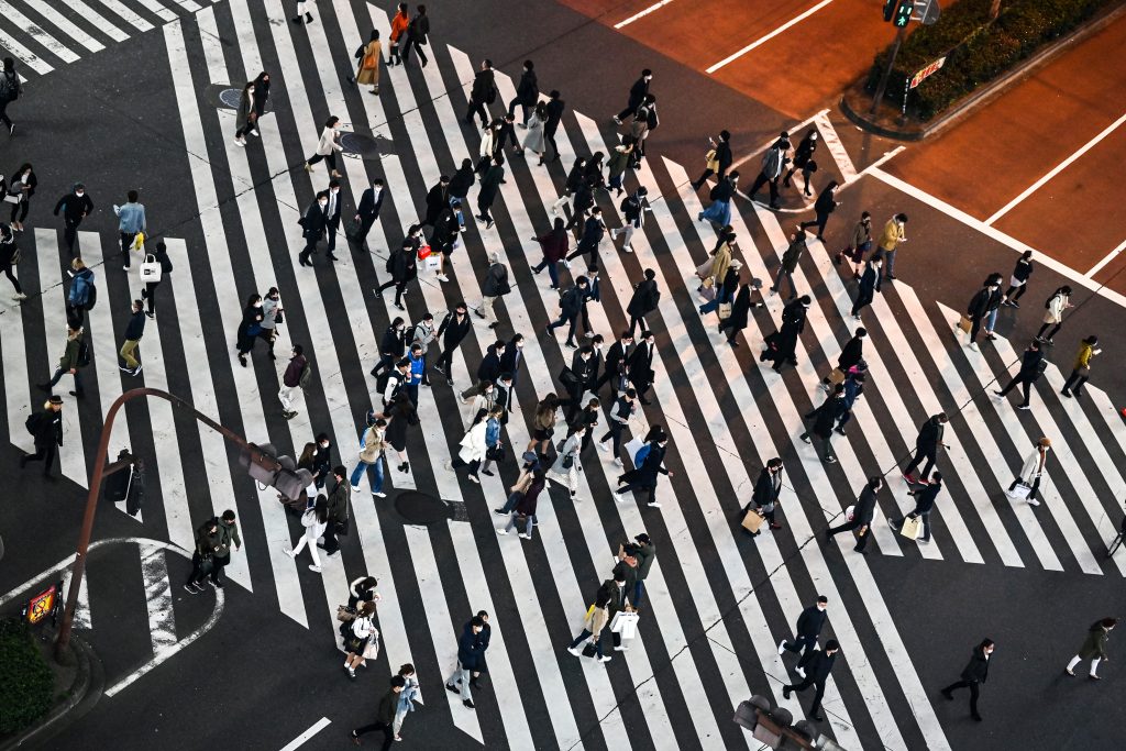 Pedestrians cross a street in Tokyo's Shinjuku area as the city reported 621 new coronavirus infection cases. (AFP)