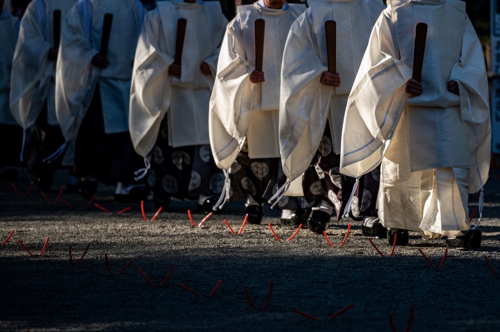Shinto priests walk in a line at Meiji Shrine before it closes early on New Year's Eve in Tokyo on December 31, 2020. (Photo by Philip FONG / AFP)