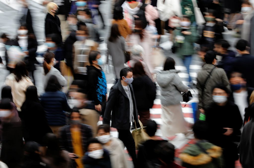 People wearing protective masks make their way amid the coronavirus disease (COVID-19) outbreak, in Tokyo, Japan, December 13, 2020. (REUTERS)