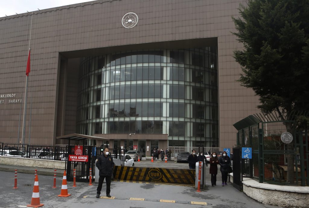 A security officer guards the entrance to a court in Istanbul, Thursday, Dec. 17, 2020, during the hearing of the case against four pilots, two flight attendants and a private airline official accused of smuggling former Nissan Motor Co. chairman Carlos Ghosn out of Japan, while awaiting trial to Lebanon via Istanbul in 2019. The court rejected a request for the pilots' travel bans to be lifted, and listened to testimonies from two ground technicians who said they saw the airline official accompanying Ghosn in Istanbul while he left one jet and boarded the next. The trial was adjourned until Jan. 20, 2021. (AP Photo/Mehmet Guzel)