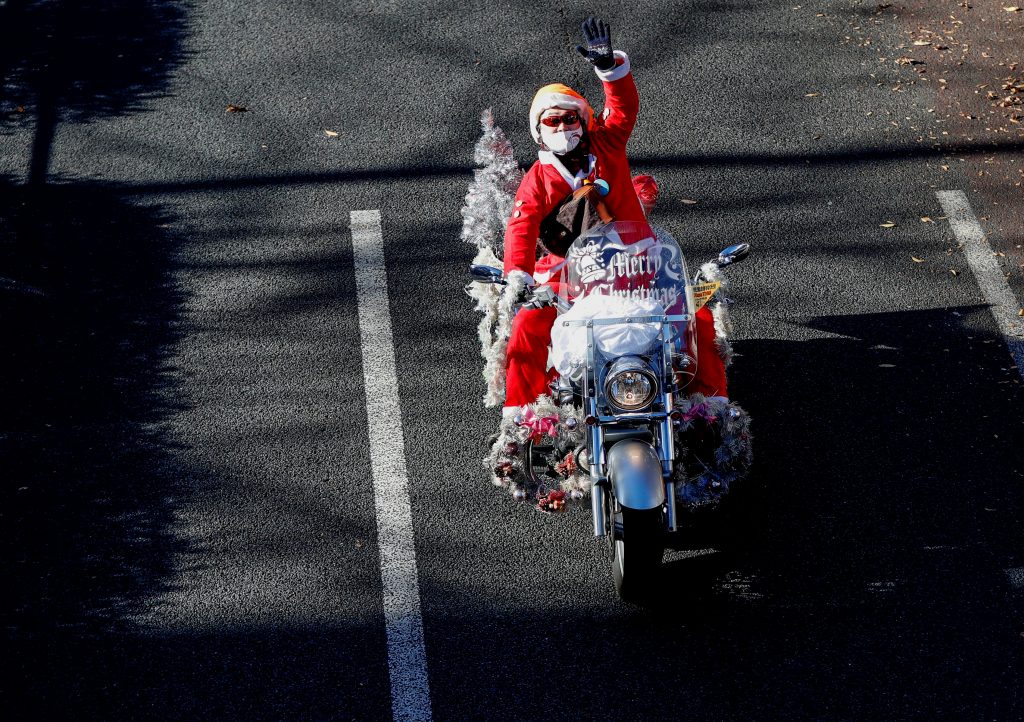 A man dressed in Santa Claus costume rides his motorbike during Xmas Toy Run parade to rev up the holiday spirit and rally against child abuse, organised by Harley Santa Club, amid the coronavirus disease (COVID-19) outbreak, in Tokyo, Japan December 20, 2020. (REUTERS)
