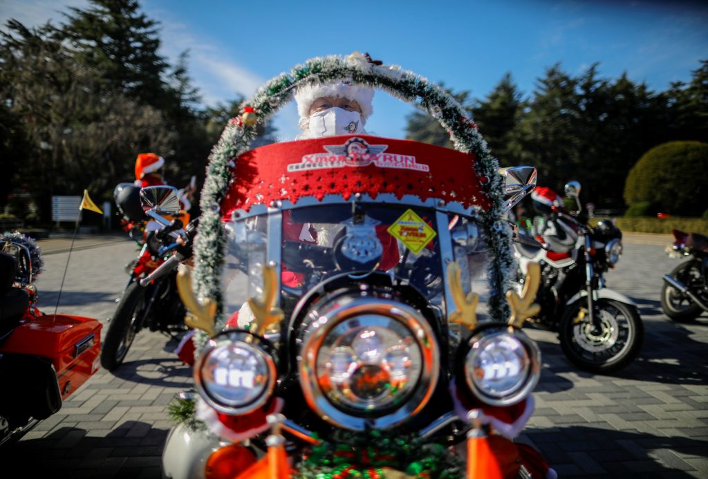 A man dressed in Santa Claus costume wearing protective face mask rides his motorbike before Xmas Toy Run parade to rev up the holiday spirit and rally against child abuse, organised by Harley Santa Club, amid the coronavirus disease (COVID-19) outbreak, in Tokyo, Japan December 20, 2020. (REUTERS)