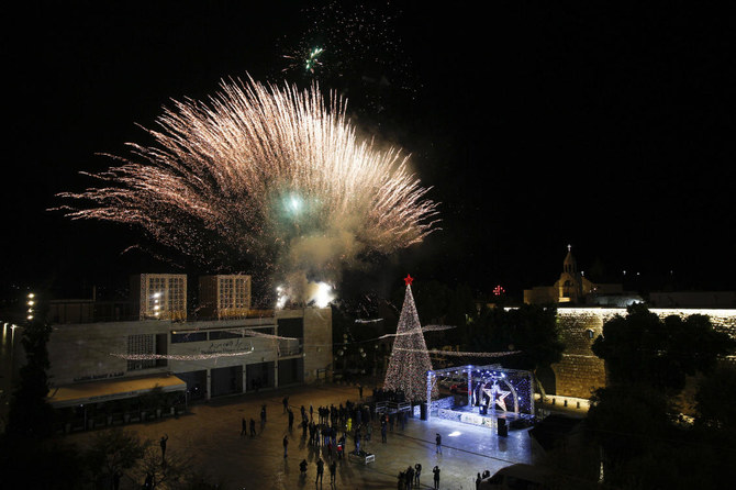 Palestinian Christians attend the lighting of a Christmas tree outside the Church of the Nativity, traditionally believed by Christians to be the birthplace of Jesus Christ in the West Bank city of Bethlehem, Saturday, Dec. 5, 2020. (AP)