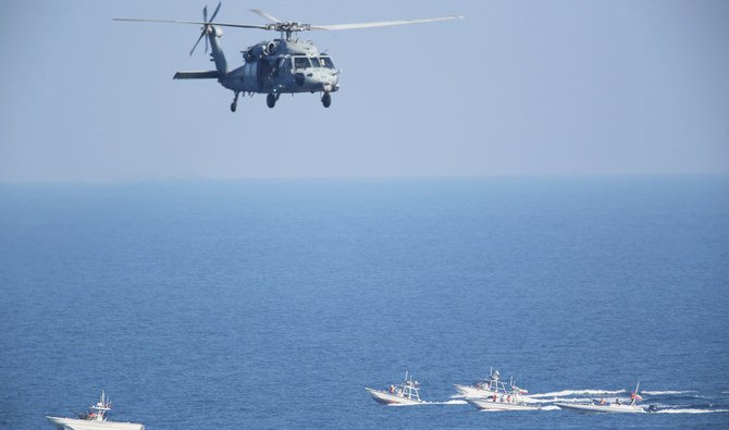 A US MH-60 Seahawk helicopter flies over Revolutionary Guard patrol boats in the Strait of Hormuz, as tensions run high over the Iranian nuclear program. (AP)