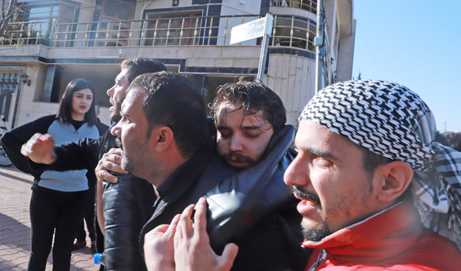 Iraqi Kurds help a wounded man during a protest against Kurdish authorities accused of corruption outside a local government building in Iraq's northeastern city of Sulaimaniyah on December 11, 2020. (AFP)