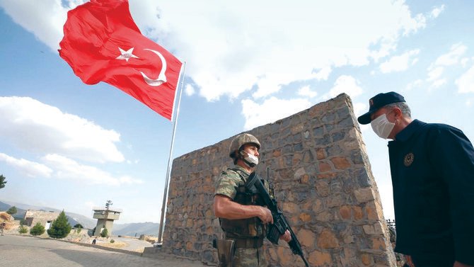 Turkish minister Hulusi Akar speaks to a soldier while visiting near the border with Iraq. Baghdad views Turkey’s raids on the PKK in Iraq as a violation of its sovereignty. (AP)