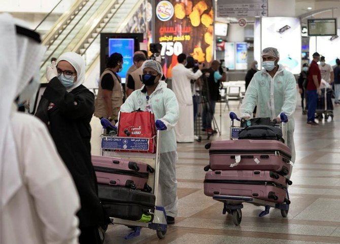Repatriated Kuwaitis from Amman, wearing protective face masks and suits, are seen after arriving at the Kuwait Airport, following the outbreak of the coronavirus disease (COVID-19), in Kuwait City, Kuwait April 21, 2020. (Reuters)